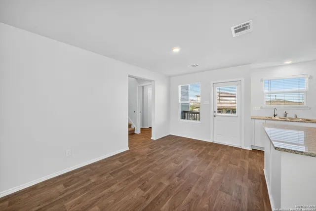a view of a kitchen with wooden floor and a sink