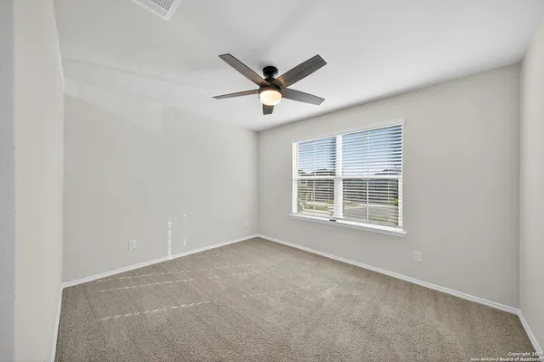 an empty room with a window and a fan