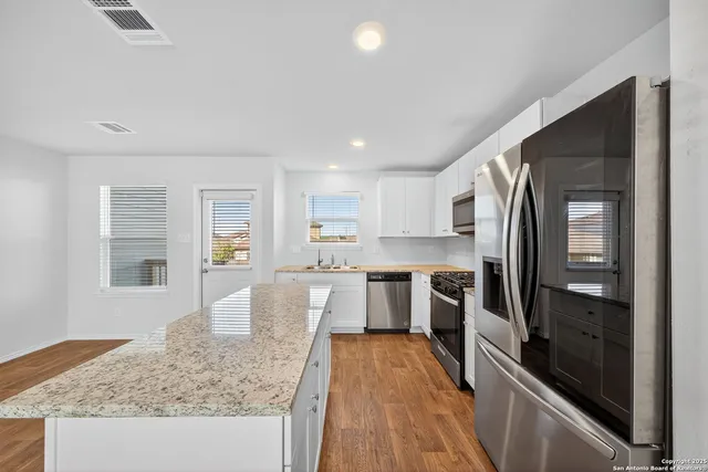 a large kitchen with kitchen island granite countertop a large counter top stainless steel appliances and cabinets