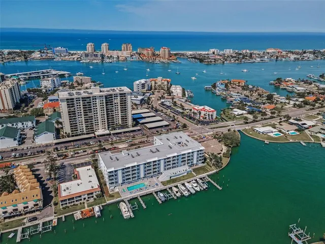 an aerial view of a city with lots of residential buildings ocean and mountain view in back