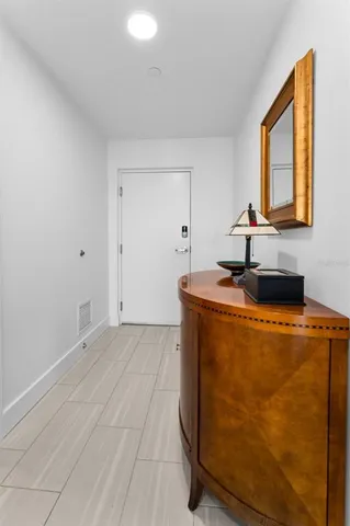 a living room with stainless steel appliances kitchen island granite countertop a stove and white cabinets