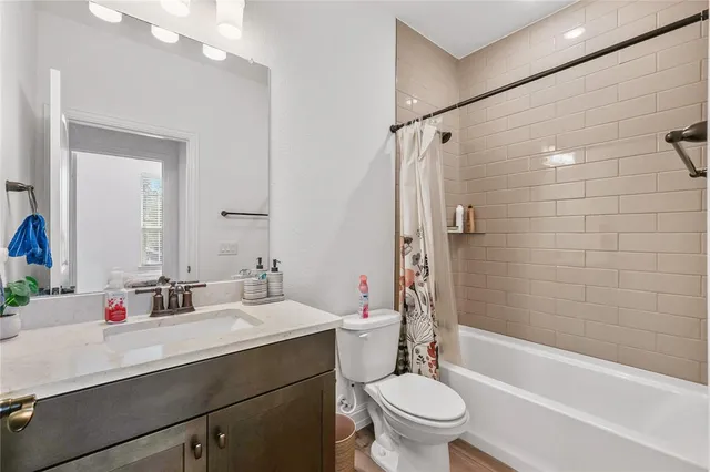 a bathroom with a sink a toilet a mirror a bathtub and shower