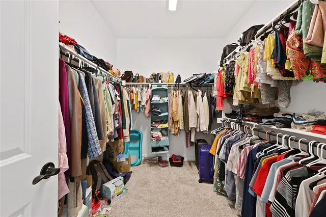 a view of walk in closet with clothes