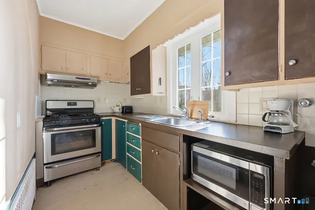 a kitchen with cabinets stainless steel appliances and sink