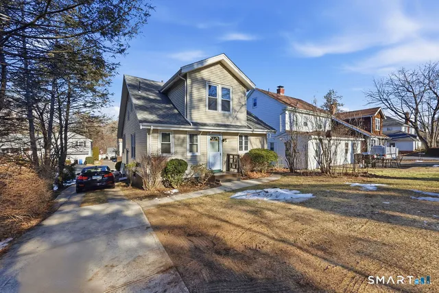 a view of a big house with large trees and playing area