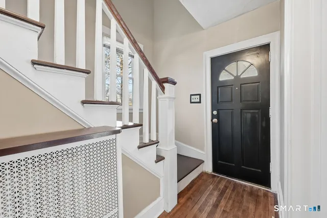 a view of a hallway with wooden floor and staircase