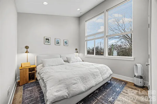 a bedroom with a bed and a large window