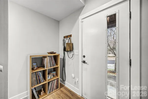 a view of a hallway with wooden floor and closet