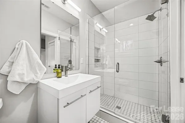 a bathroom with a sink shower and a mirror