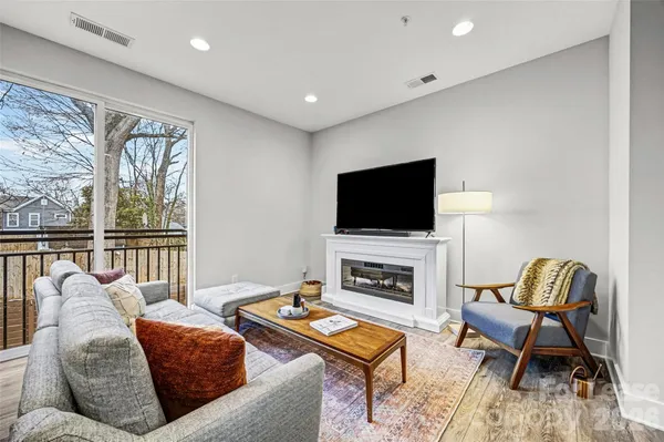 a living room with furniture a flat screen tv and a fireplace