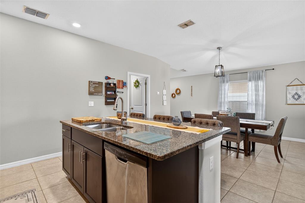 9645 Lemon Drop Loop Ruskin, FL 33573 - Photo 14 of 49 a room with granite countertop a table and chairs in it