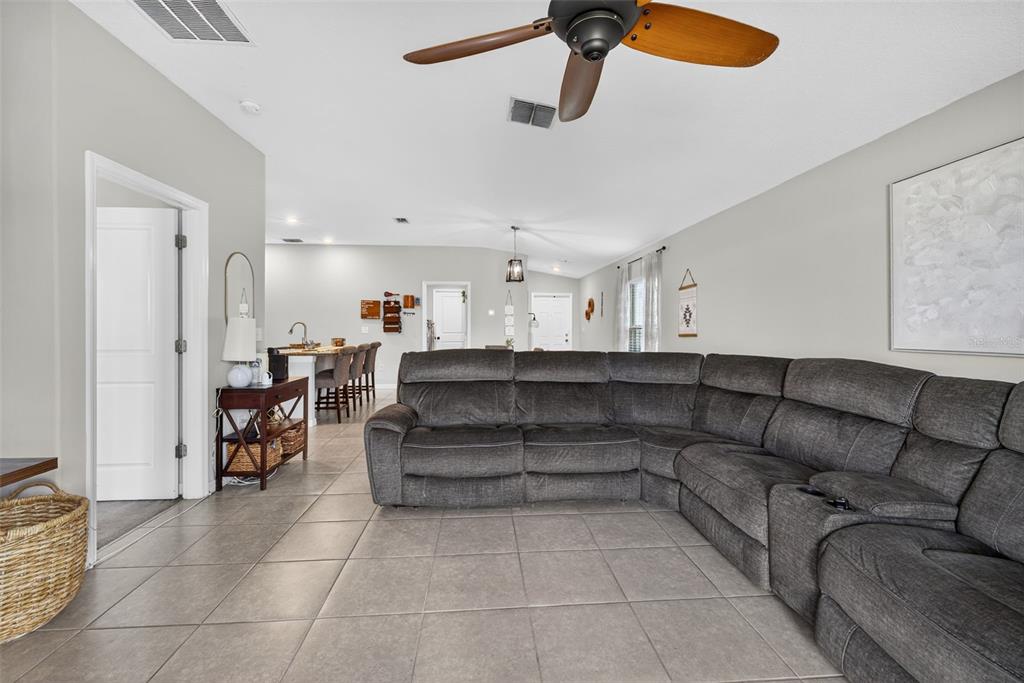 9645 Lemon Drop Loop Ruskin, FL 33573 - Photo 18 of 49 a living room with a couch and a ceiling fan