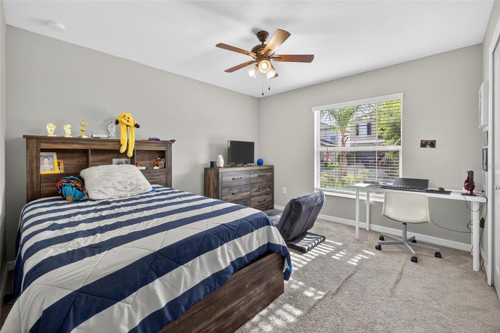 9645 Lemon Drop Loop Ruskin, FL 33573 - Photo 20 of 49 a bedroom with a bed a large window with table and chairs