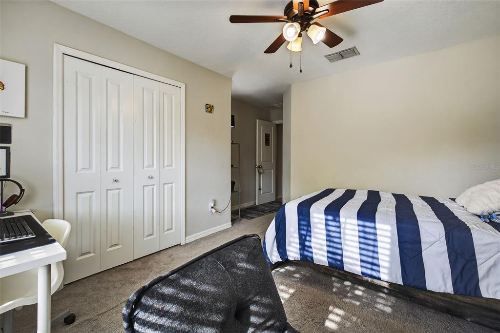 9645 Lemon Drop Loop Ruskin, FL 33573 - Photo 21 of 49 a bedroom with a bed and a chandelier