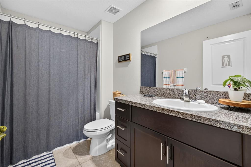 9645 Lemon Drop Loop Ruskin, FL 33573 - Photo 24 of 49 a bathroom with a granite countertop sink toilet a mirror a vanity and shower