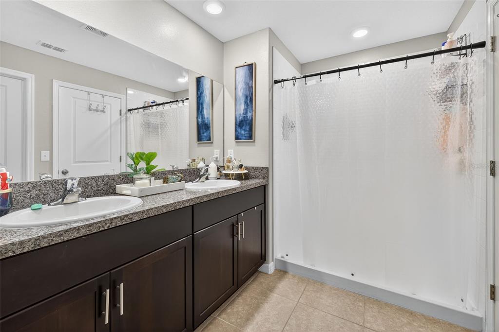 9645 Lemon Drop Loop Ruskin, FL 33573 - Photo 30 of 49 a bathroom with a granite countertop sink and a mirror