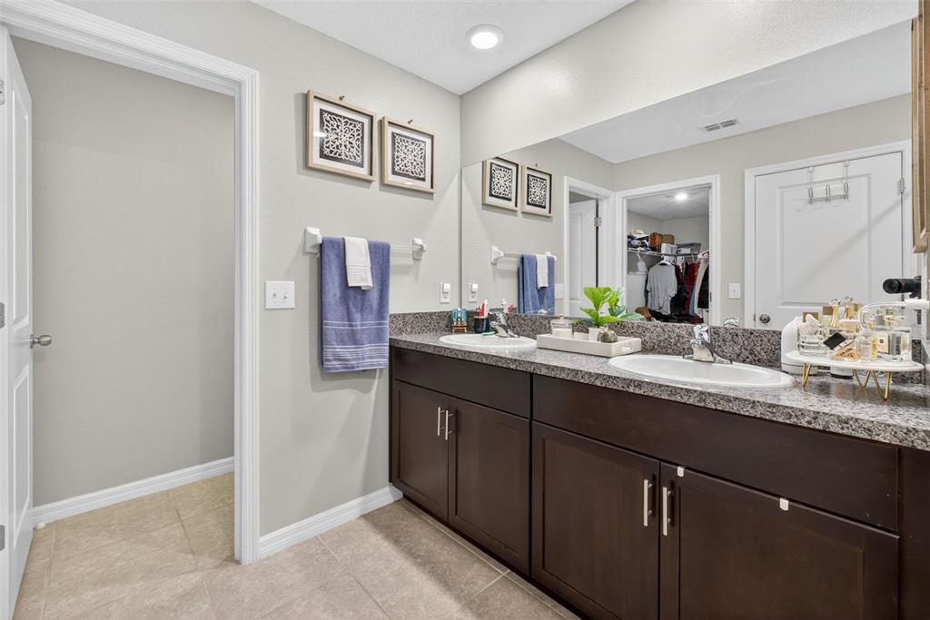 9645 Lemon Drop Loop Ruskin, FL 33573 - Photo 31 of 49 a bathroom with a double vanity sink and a mirror