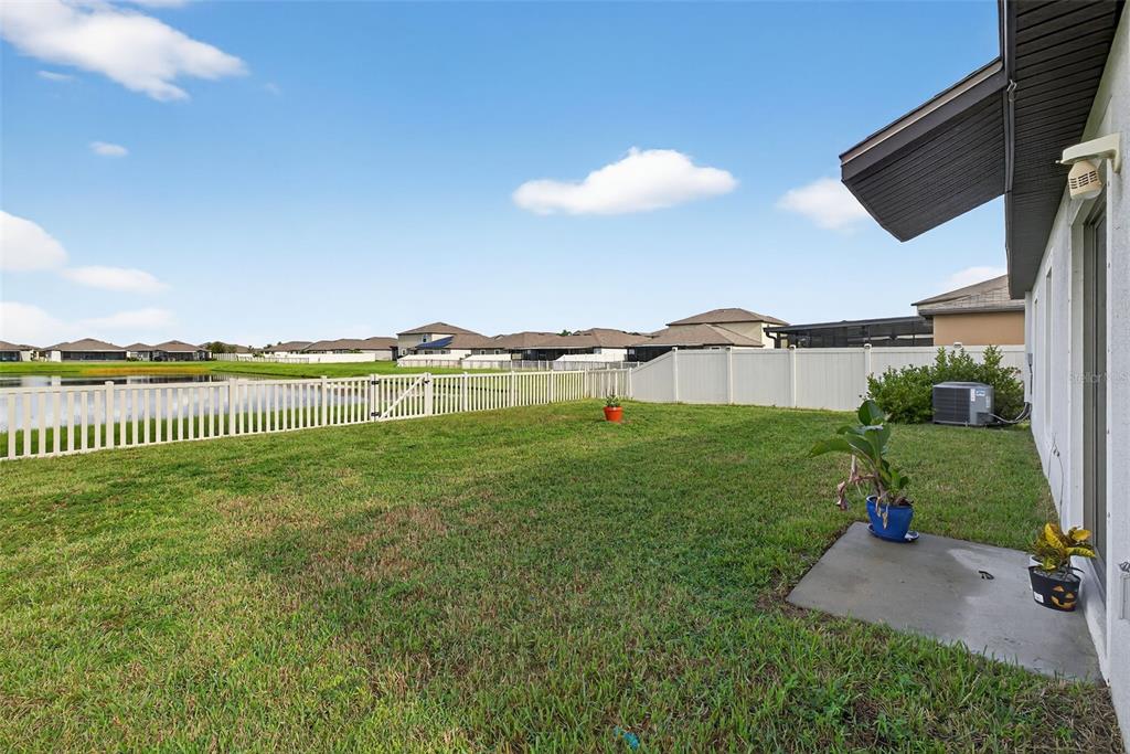 9645 Lemon Drop Loop Ruskin, FL 33573 - Photo 34 of 49 a view of a green yard next to a larger building