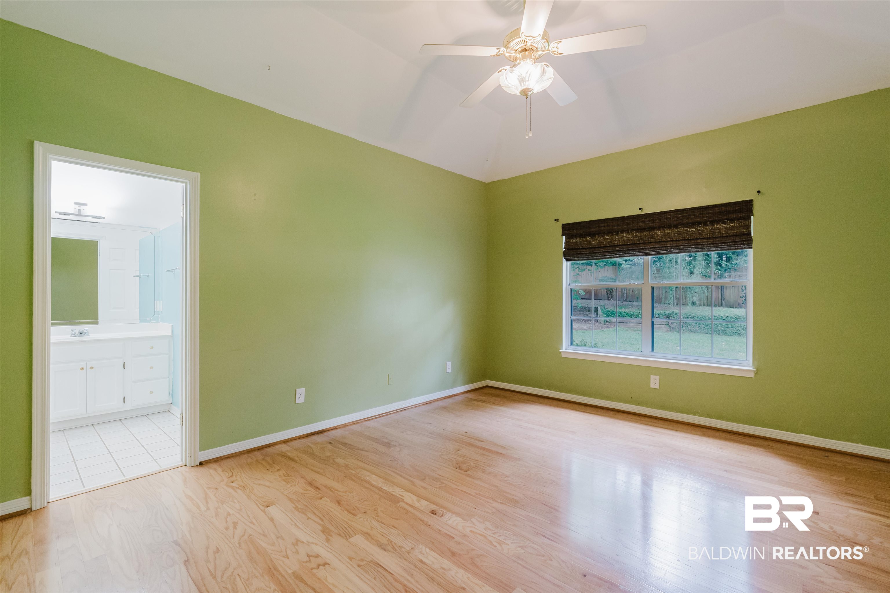 19711 Hunters Loop Fairhope, AL 36532 - Photo 18 of 49 Unfurnished room featuring wood finished floors, a ceiling fan, baseboards, and a sink