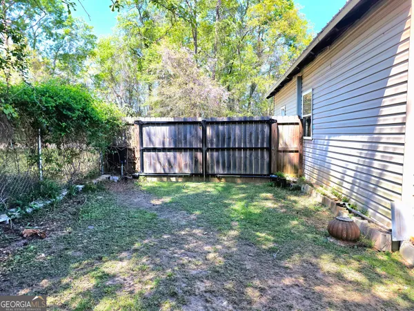 a view of a backyard with plants and wooden fence