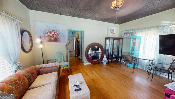 a living room with furniture a flat screen tv and a large window
