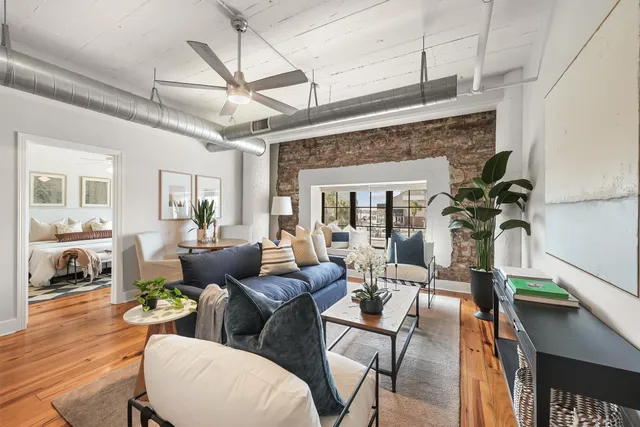 a living room with furniture a flat screen tv and a floor to ceiling window