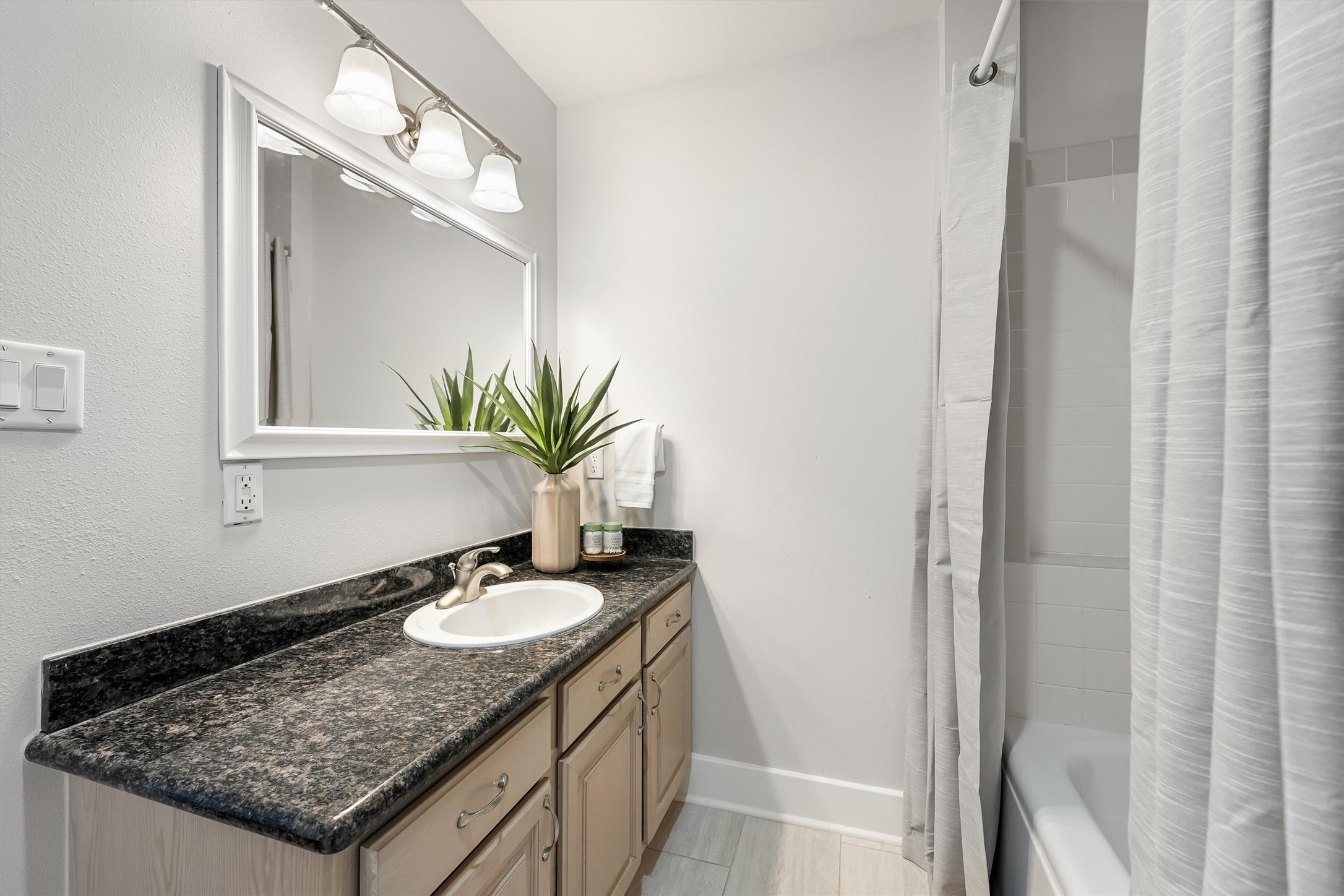 104 21st Street, Unit 203 Galveston, TX 77550 - Photo 13 of 27 a bathroom with a granite countertop sink and a mirror