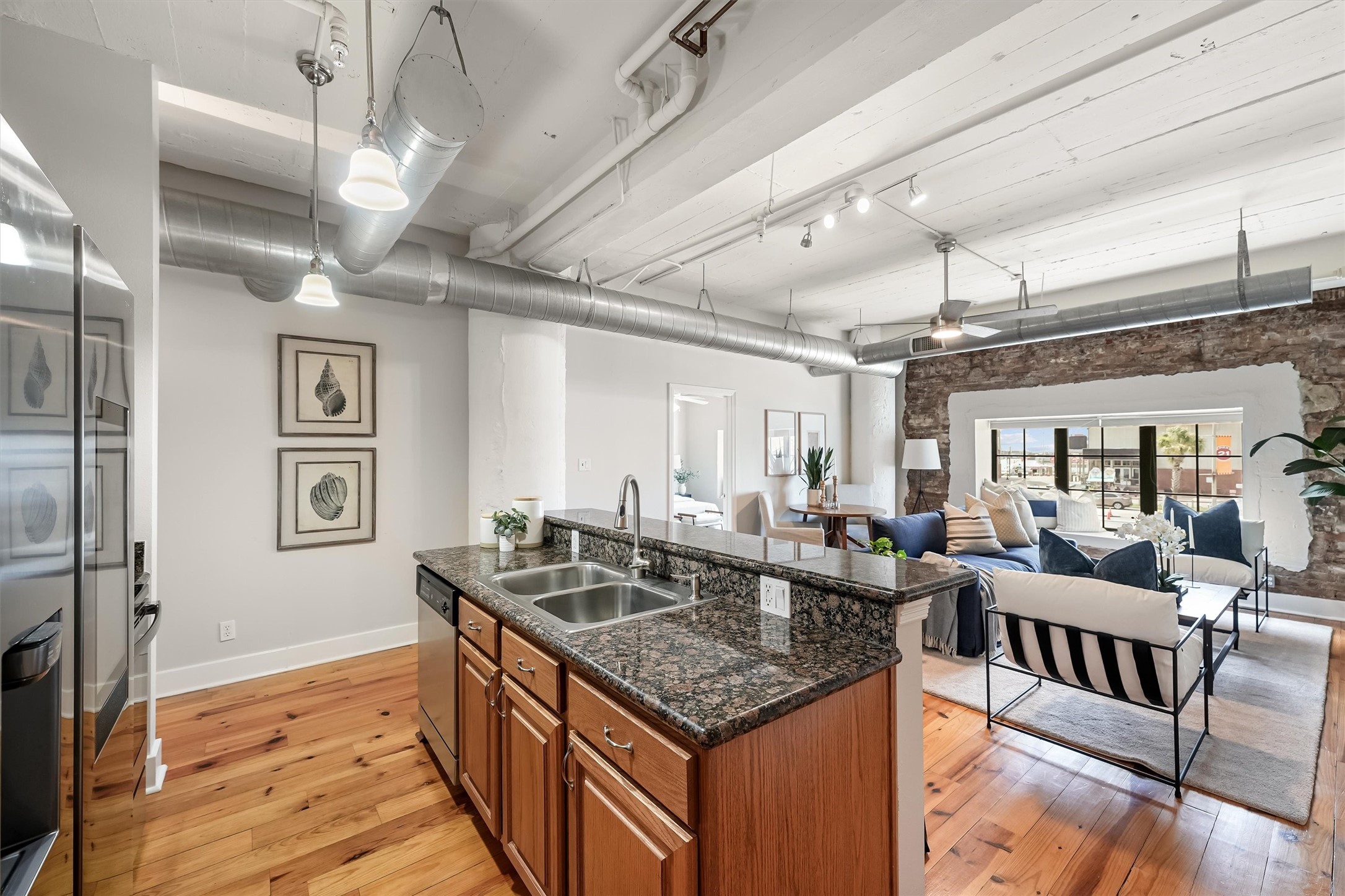104 21st Street, Unit 203 Galveston, TX 77550 - Photo 3 of 27 a kitchen with stainless steel appliances granite countertop a sink and wooden cabinets