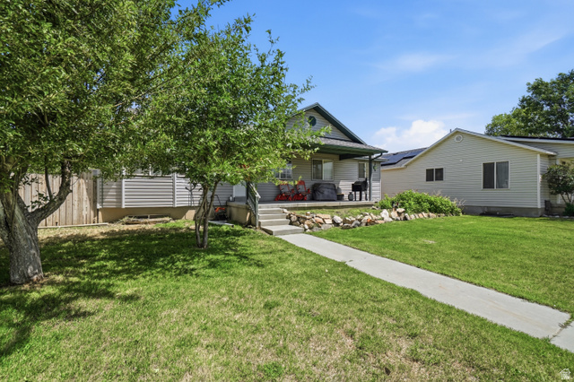 2135 East White Pine Road Eagle Mountain, UT 84005 - Photo 22 of 23 Exterior featuring a covered porch, concrete entry steps, and a sidewalk leading through a green lawn