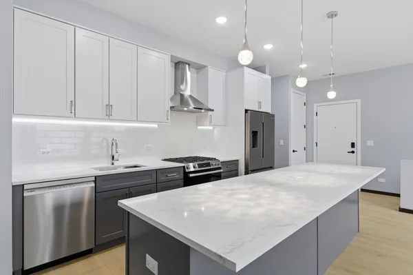 a kitchen with a sink a stove a refrigerator and white cabinets