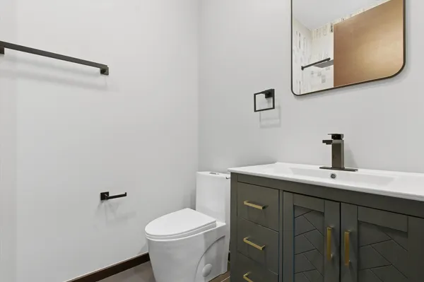 a bathroom with a toilet sink and mirror