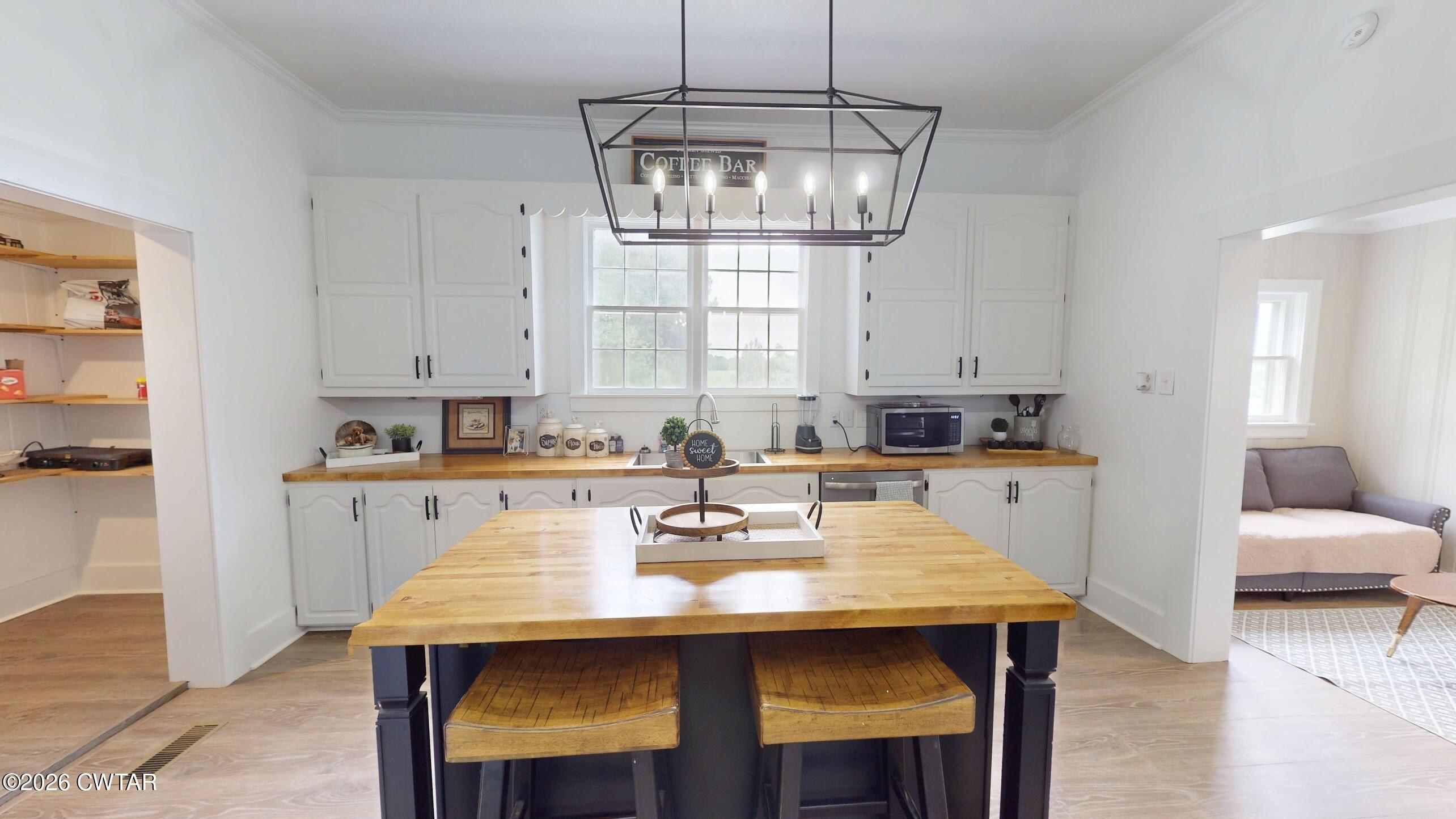 2800 Locust Grove Road Newbern, TN 38059 - Photo 16 of 46 a kitchen with a table chairs and white cabinets