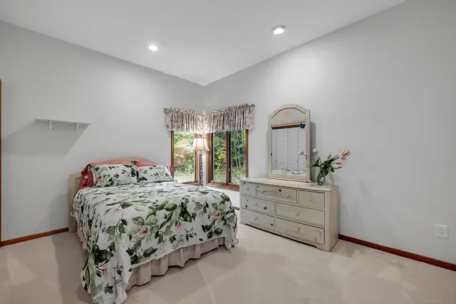 a bedroom with a bed and a large window