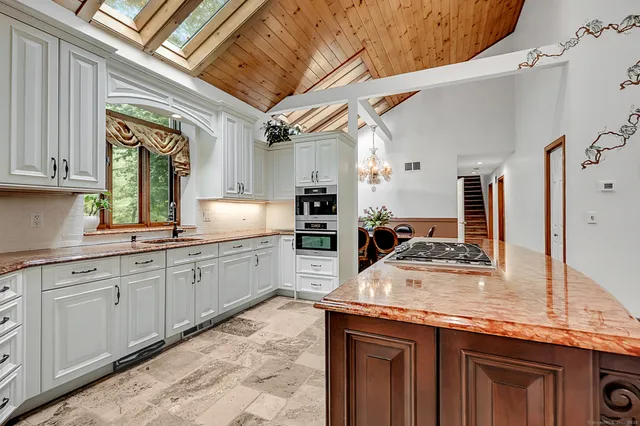 a kitchen with stainless steel appliances granite countertop a sink a stove and cabinets