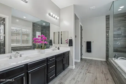 a bathroom with a granite countertop sink a large mirror and shower