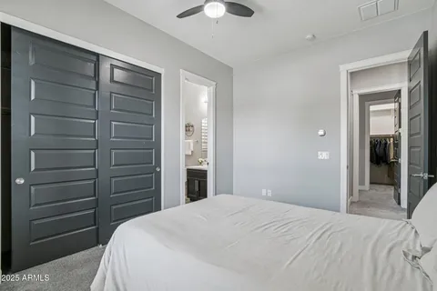 a bedroom with a bed and a ceiling fan