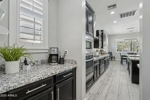 a kitchen with stainless steel appliances granite countertop sink stove top oven and cabinets