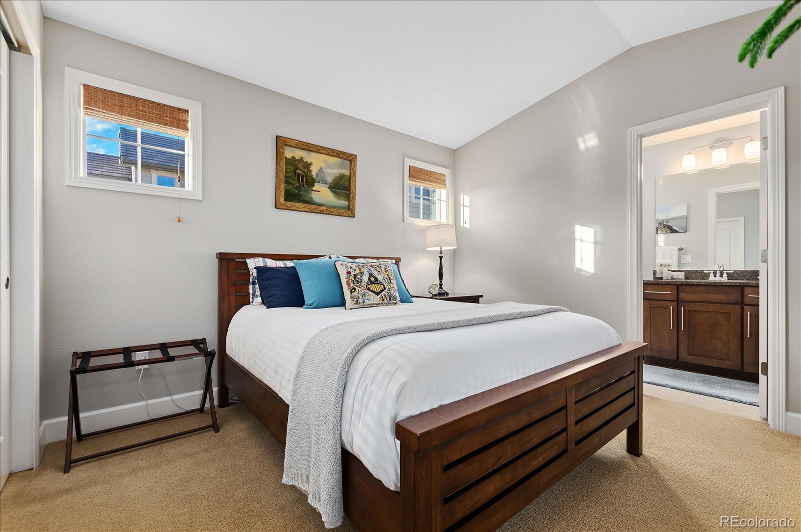 10654 Sundial Rim Road Highlands Ranch, CO 80126 - Photo 12 of 40 a bedroom with a bed and a chandelier