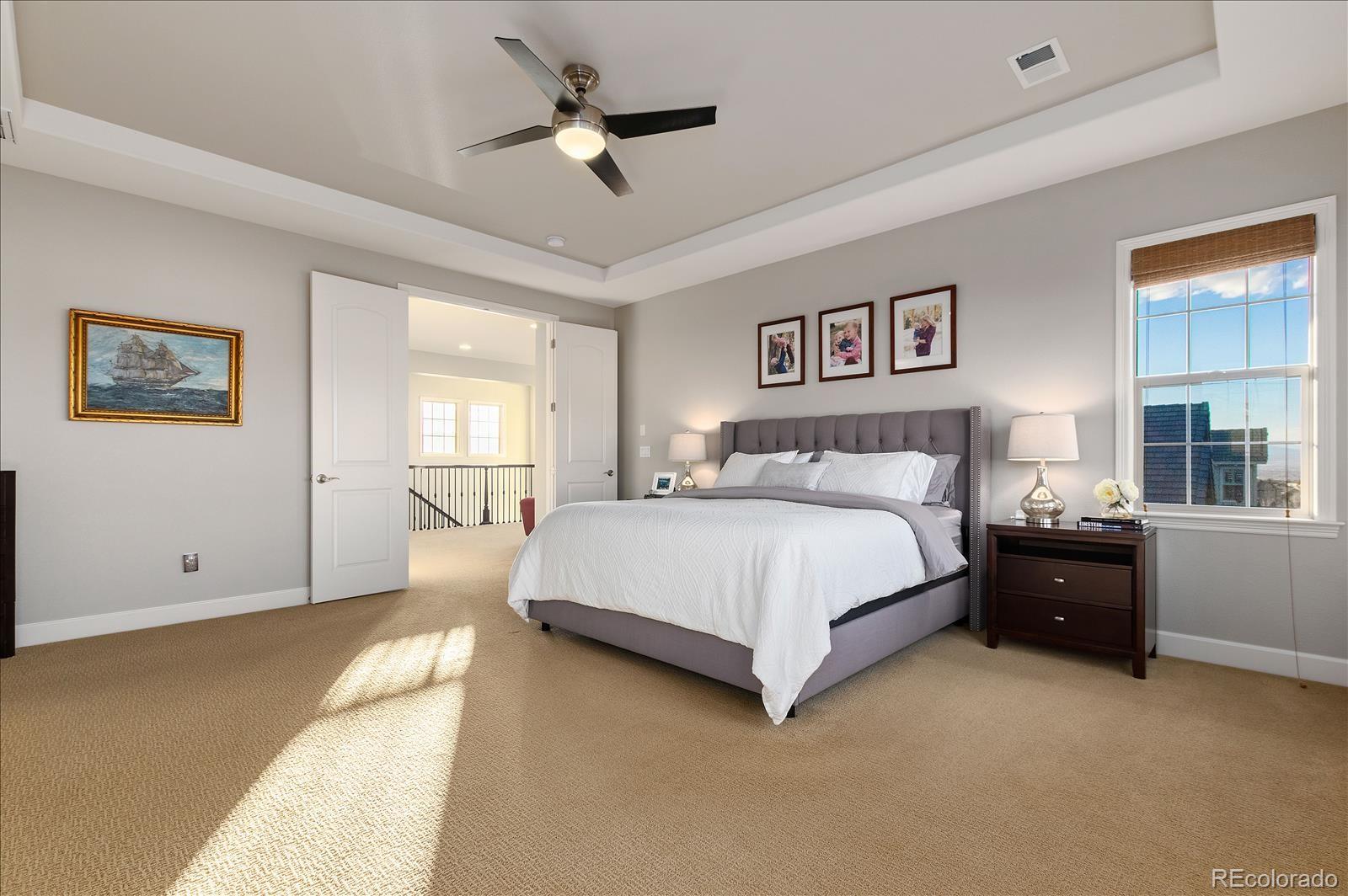 10654 Sundial Rim Road Highlands Ranch, CO 80126 - Photo 15 of 40 a spacious bedroom with a large bed and a chandelier