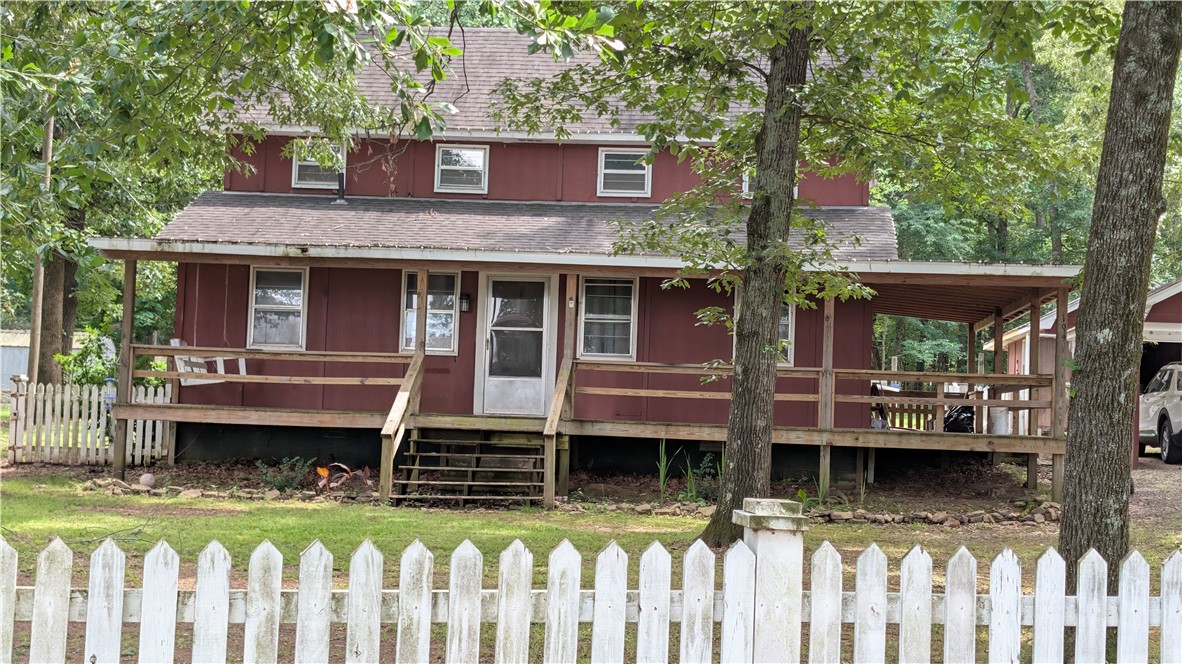 194 Pine Valley Loop Houston, AR 72070 - Photo 1 of 21 Red-sided residence featuring a covered front porch and a white picket fence