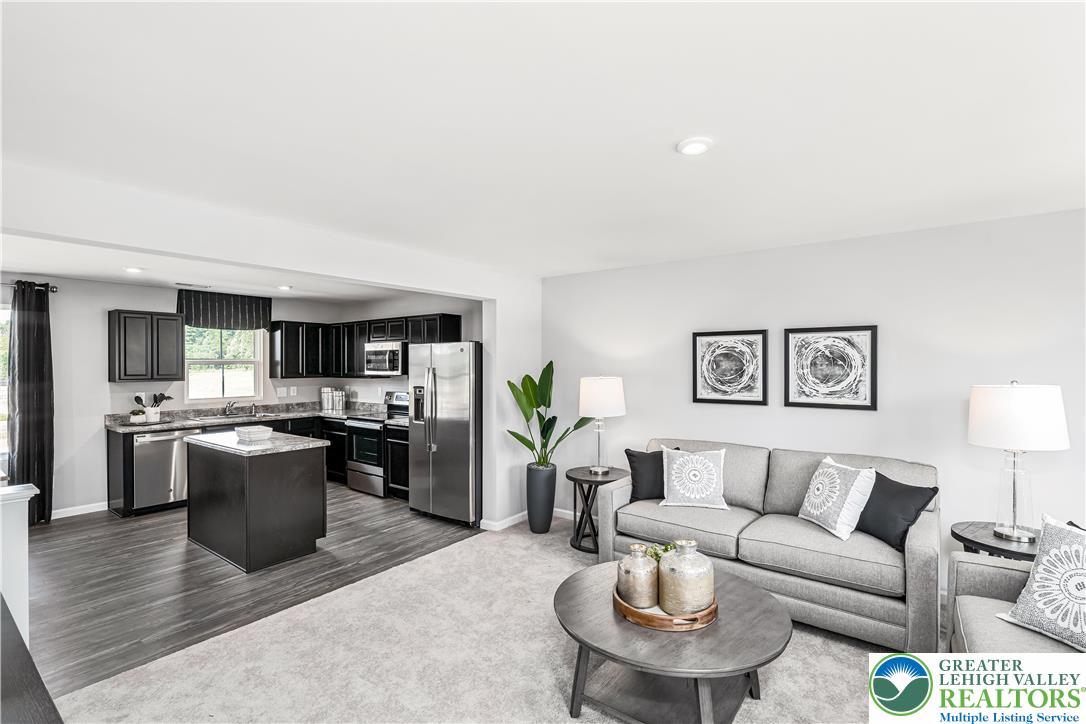 66 Shiloh Road, Unit J2 Orwigsburg, PA 17961 - Photo 11 of 14 a living room with a couch and a dining table with kitchen view