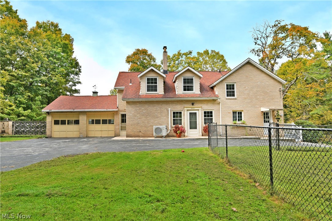 892 Yankee Run Road Masury, OH 44438 - Photo 2 of 50 Brick exterior with a dormer window, attached two-car garage, and a chain-link fence