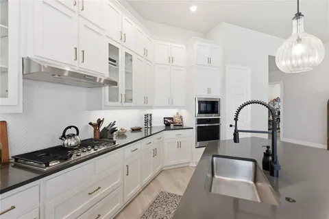 a kitchen with stainless steel appliances a sink stove and cabinets