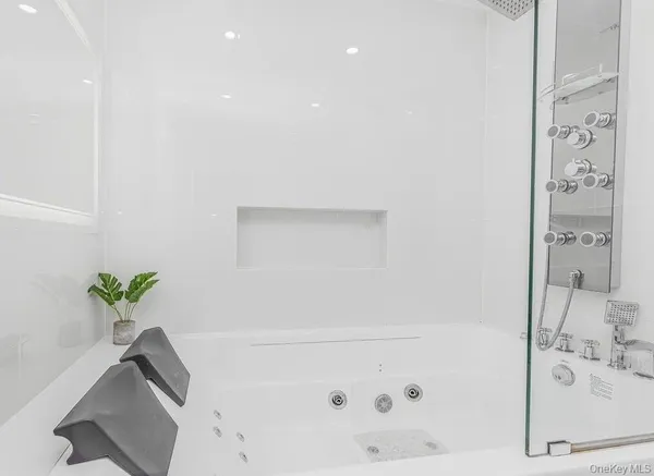 a spacious bedroom with a bed a couch and a flat tv screen next to a window