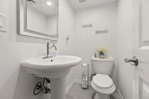 a bathroom with a sink a toilet and a large mirror