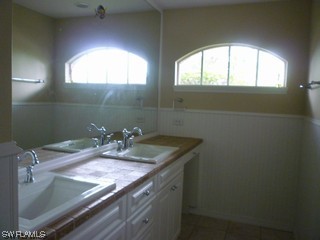 18554 Olive Road Fort Myers, FL 33967 - Photo 3 of 5 a bathroom with a granite countertop sink a toilet and mirror