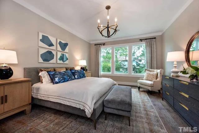 a bedroom with a large bed and a chandelier