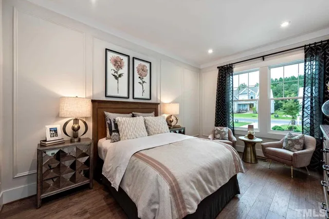 a bedroom with a bed a couch and a large window