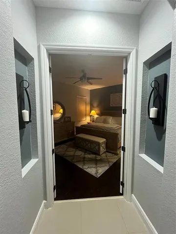 a bedroom with a bed a lamp and a flat screen tv