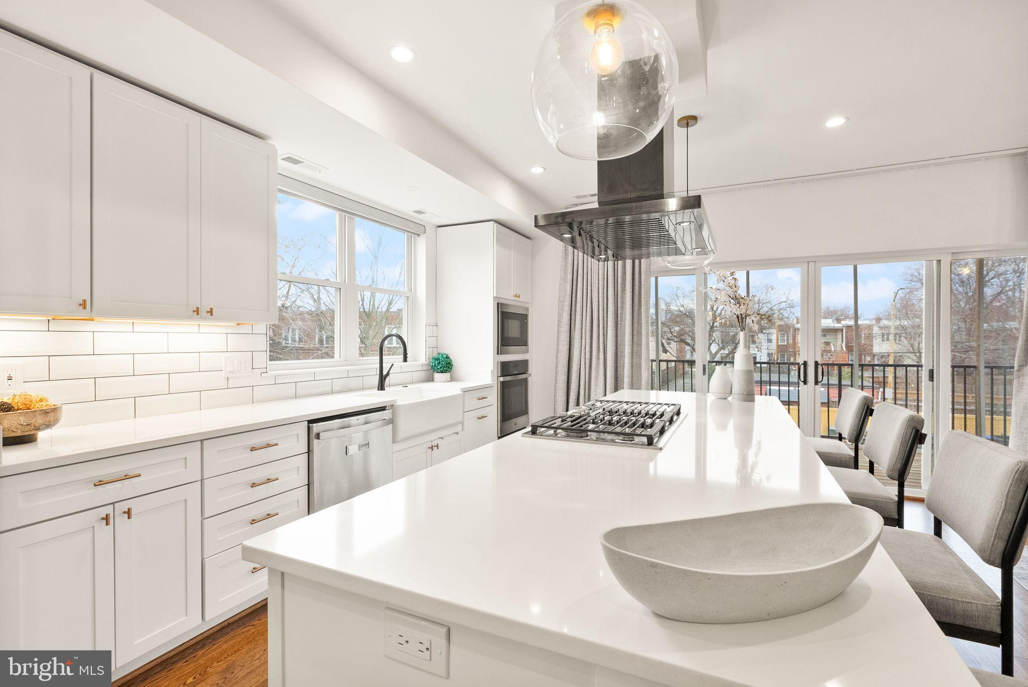 117 17th Street Southeast, Unit 2 Washington, DC 20003 - Photo 11 of 31 a large white kitchen with a large window and stainless steel appliances